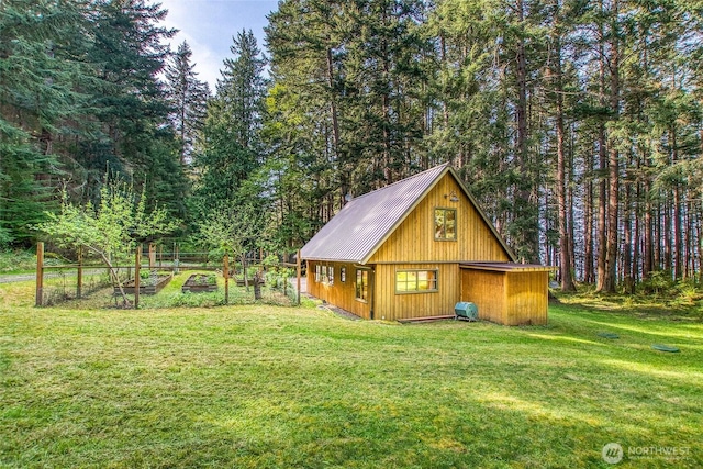 view of outbuilding with a wooded view and a vegetable garden