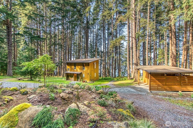 view of yard featuring an outbuilding and a forest view