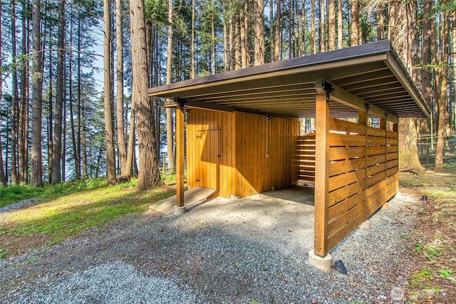 view of outbuilding with gravel driveway and a carport