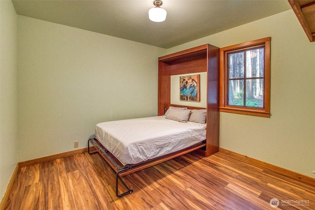bedroom featuring wood finished floors and baseboards
