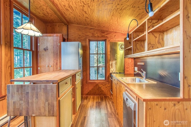 kitchen with a sink, wood finished floors, butcher block counters, vaulted ceiling, and plenty of natural light