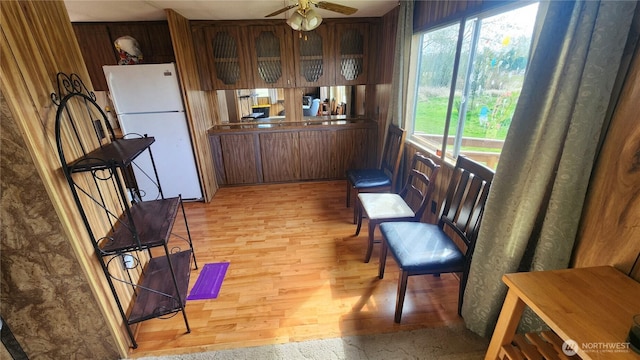 8458 Shintaffer Rd, Blaine, WA 98230 - kitchen featuring glass insert cabinets, light wood-type flooring, freestanding refrigerator, a ceiling fan, and brown cabinets
