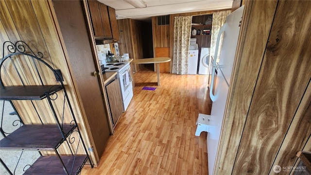8458 Shintaffer Rd, Blaine, WA 98230 - kitchen featuring white appliances, light wood-style flooring, visible vents, wood walls, and washer and clothes dryer
