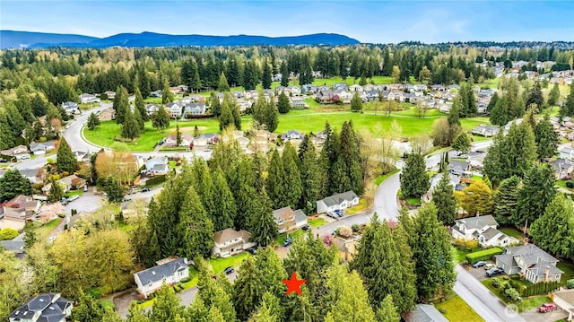 birds eye view of property with a forest view, a mountain view, and a residential view