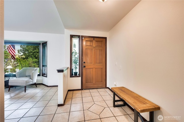 foyer with light tile patterned flooring and baseboards