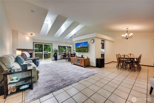 living room featuring light tile patterned floors, vaulted ceiling with skylight, an inviting chandelier, and a brick fireplace