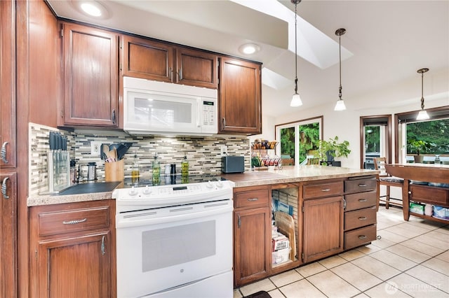 kitchen featuring white appliances, a peninsula, light tile patterned flooring, decorative light fixtures, and decorative backsplash