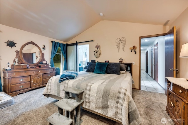 bedroom featuring light carpet, a barn door, vaulted ceiling, and light tile patterned floors