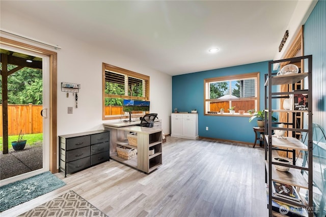 office space with baseboards and light wood finished floors