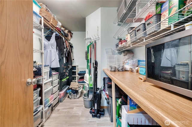 walk in closet with wood finished floors