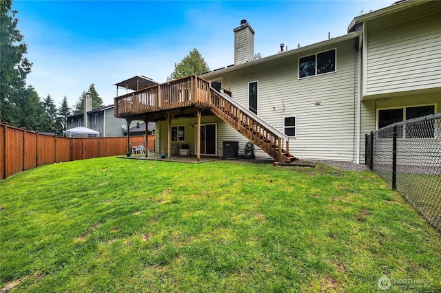 rear view of house featuring a yard, a fenced backyard, a deck, and stairs