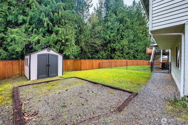 view of yard with a storage shed, a fenced backyard, an outdoor structure, and stairway