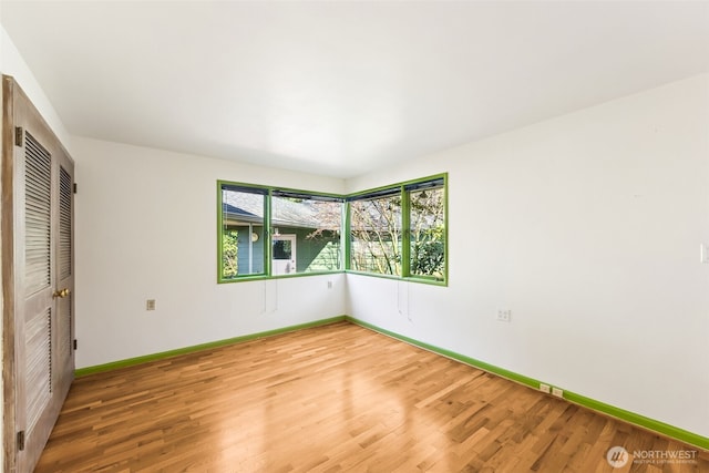 unfurnished bedroom with light wood-style floors, baseboards, and a closet