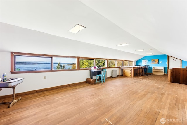 office space with light wood-type flooring, baseboards, lofted ceiling, and radiator heating unit