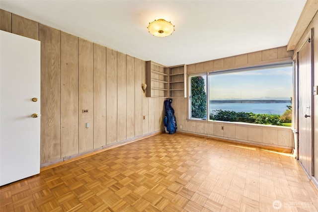 empty room featuring wooden walls and a water view