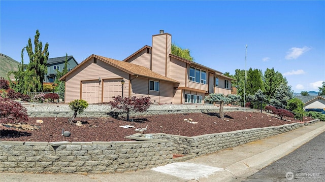 view of front of home featuring a garage and a chimney