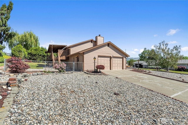 view of front facade featuring an attached garage, fence, concrete driveway, a chimney, and stairs