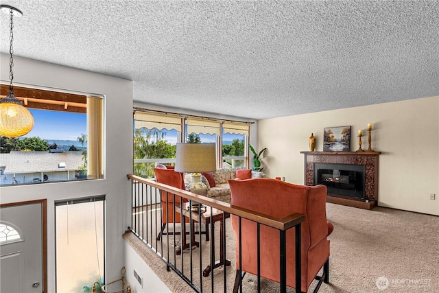 carpeted living room featuring a textured ceiling and a tile fireplace