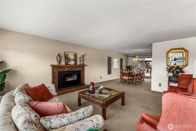 living area featuring carpet flooring, a textured ceiling, a glass covered fireplace, and a chandelier