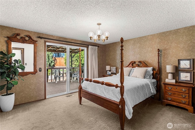 carpeted bedroom featuring access to exterior, a chandelier, and a textured ceiling