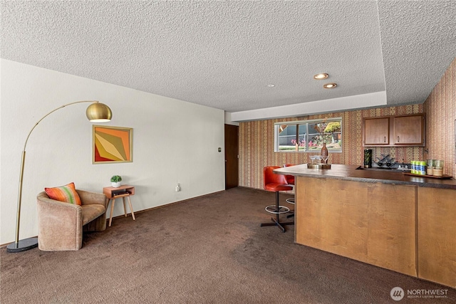 carpeted office space with a textured ceiling and wallpapered walls