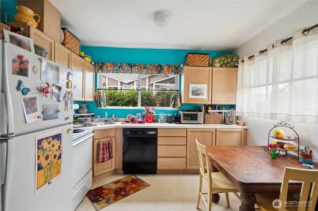 kitchen featuring light countertops, light brown cabinetry, and white appliances