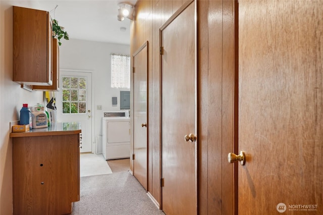 corridor with washer / dryer, light carpet, and electric panel