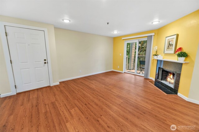 975 Aberdeen Ave NE Unit F207, Renton, WA 98056 - unfurnished living room with a premium fireplace, wood finished floors, and baseboards