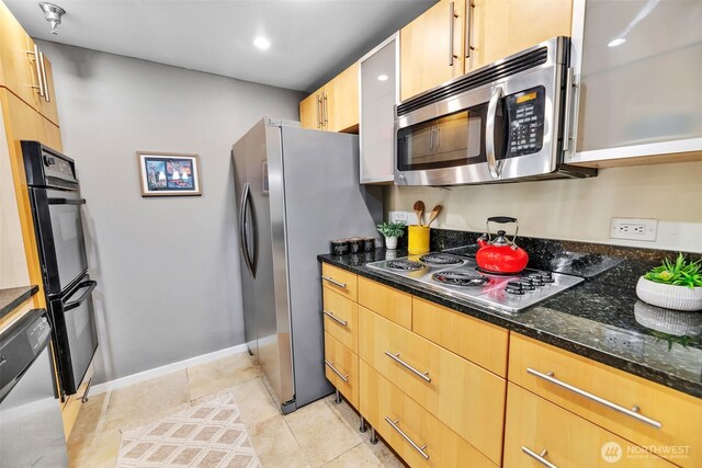 975 Aberdeen Ave NE Unit F207, Renton, WA 98056 - kitchen with baseboards, light brown cabinets, dark stone counters, stainless steel appliances, and light tile patterned flooring