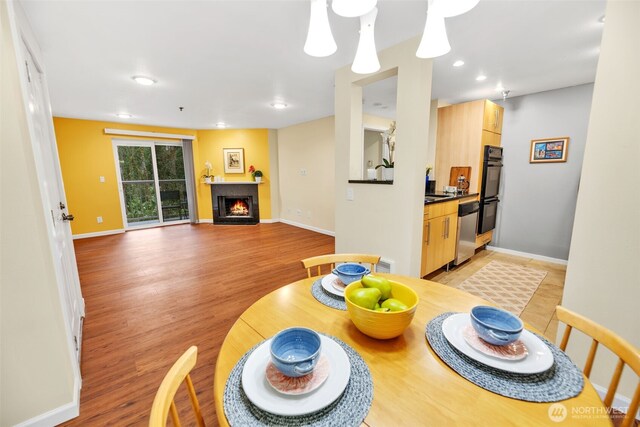 975 Aberdeen Ave NE Unit F207, Renton, WA 98056 - dining room with baseboards, a warm lit fireplace, recessed lighting, light wood-style flooring, and visible vents