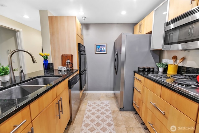 975 Aberdeen Ave NE Unit F207, Renton, WA 98056 - kitchen featuring dark stone countertops, baseboards, a sink, appliances with stainless steel finishes, and light tile patterned flooring