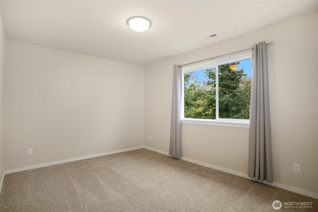 carpeted empty room featuring visible vents and baseboards