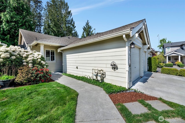exterior space with roof with shingles, an attached garage, and concrete driveway