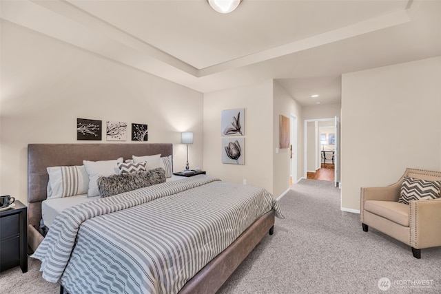 carpeted bedroom featuring baseboards and a tray ceiling