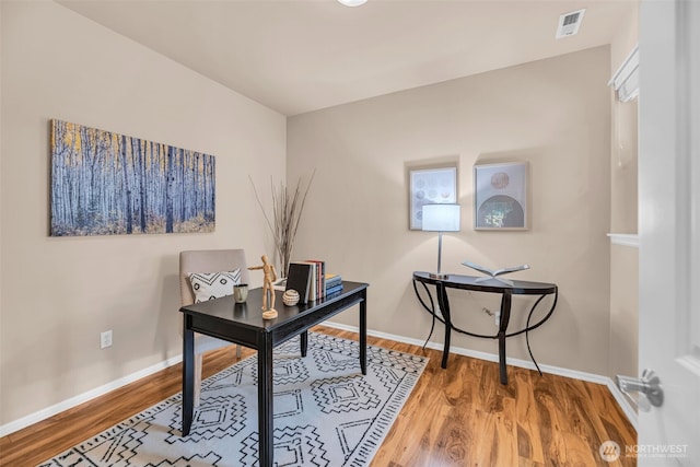 office area with baseboards, wood finished floors, and visible vents
