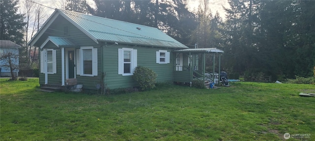view of side of property featuring a yard and metal roof