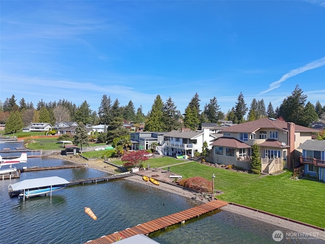 view of dock featuring a water view, a residential view, and a lawn