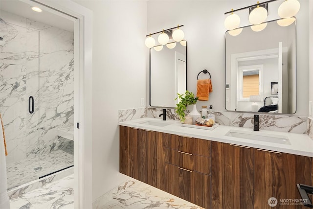 bathroom with double vanity, marble finish floor, a sink, and a marble finish shower