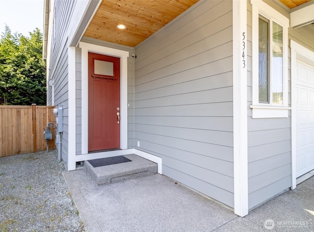 view of exterior entry featuring fence