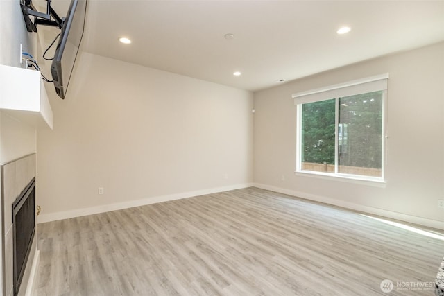 unfurnished living room featuring recessed lighting, baseboards, and light wood-type flooring