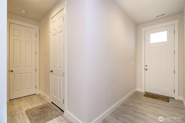 entryway with light wood-type flooring, visible vents, and baseboards