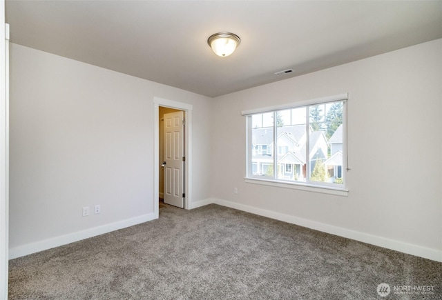 empty room featuring baseboards, visible vents, and carpet
