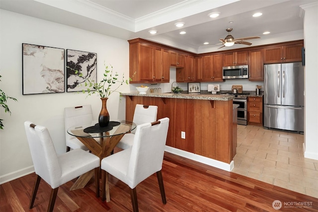 10047 Main St Unit 413, Bellevue, WA 98004 - kitchen with stainless steel appliances, crown molding, recessed lighting, a peninsula, and light stone countertops