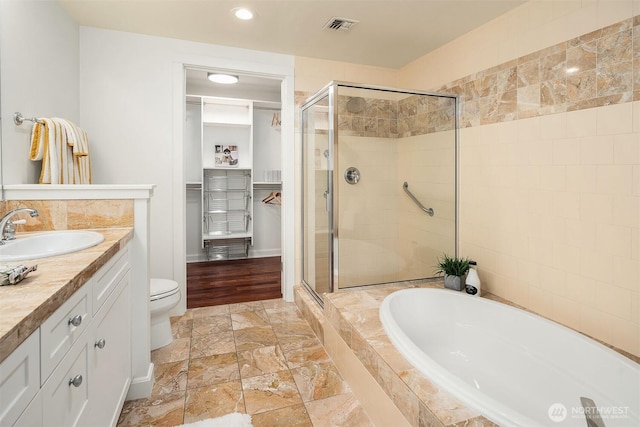10047 Main St Unit 413, Bellevue, WA 98004 - full bathroom featuring a stall shower, a bath, vanity, recessed lighting, and a spacious closet