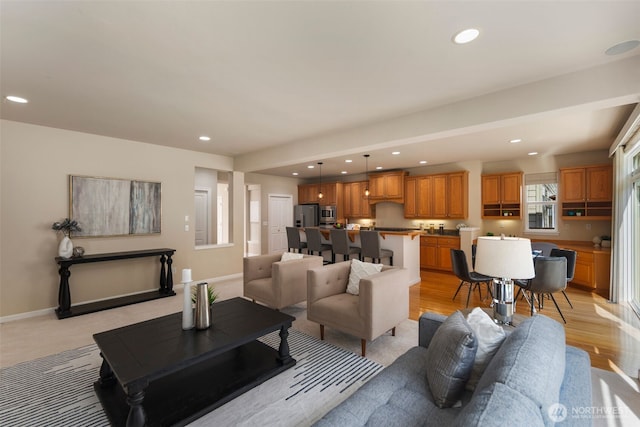 living area featuring recessed lighting and baseboards