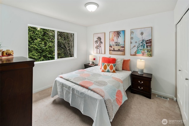 bedroom featuring visible vents, baseboards, a closet, and light carpet