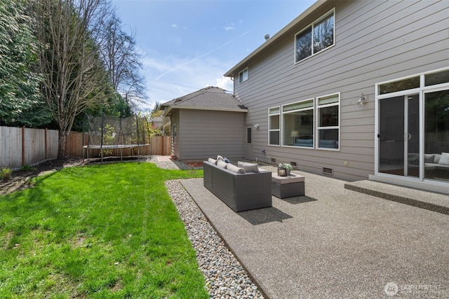 rear view of house with a yard, a patio area, a trampoline, a fenced backyard, and an outdoor living space