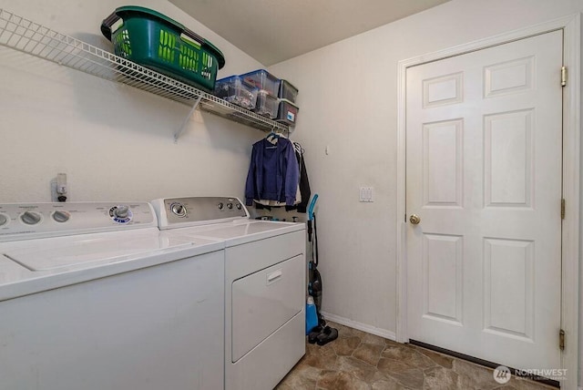 clothes washing area featuring baseboards, laundry area, and washing machine and dryer