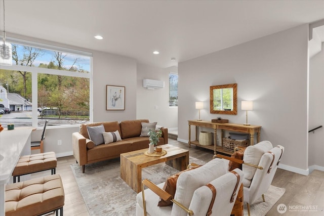 living area with light wood-style floors, baseboards, an AC wall unit, and recessed lighting