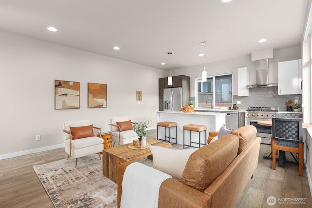 living area with light wood-style floors, baseboards, and recessed lighting